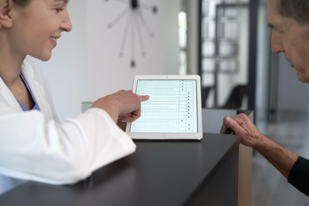 Senior patient completes the questionnaire at registering to doctor