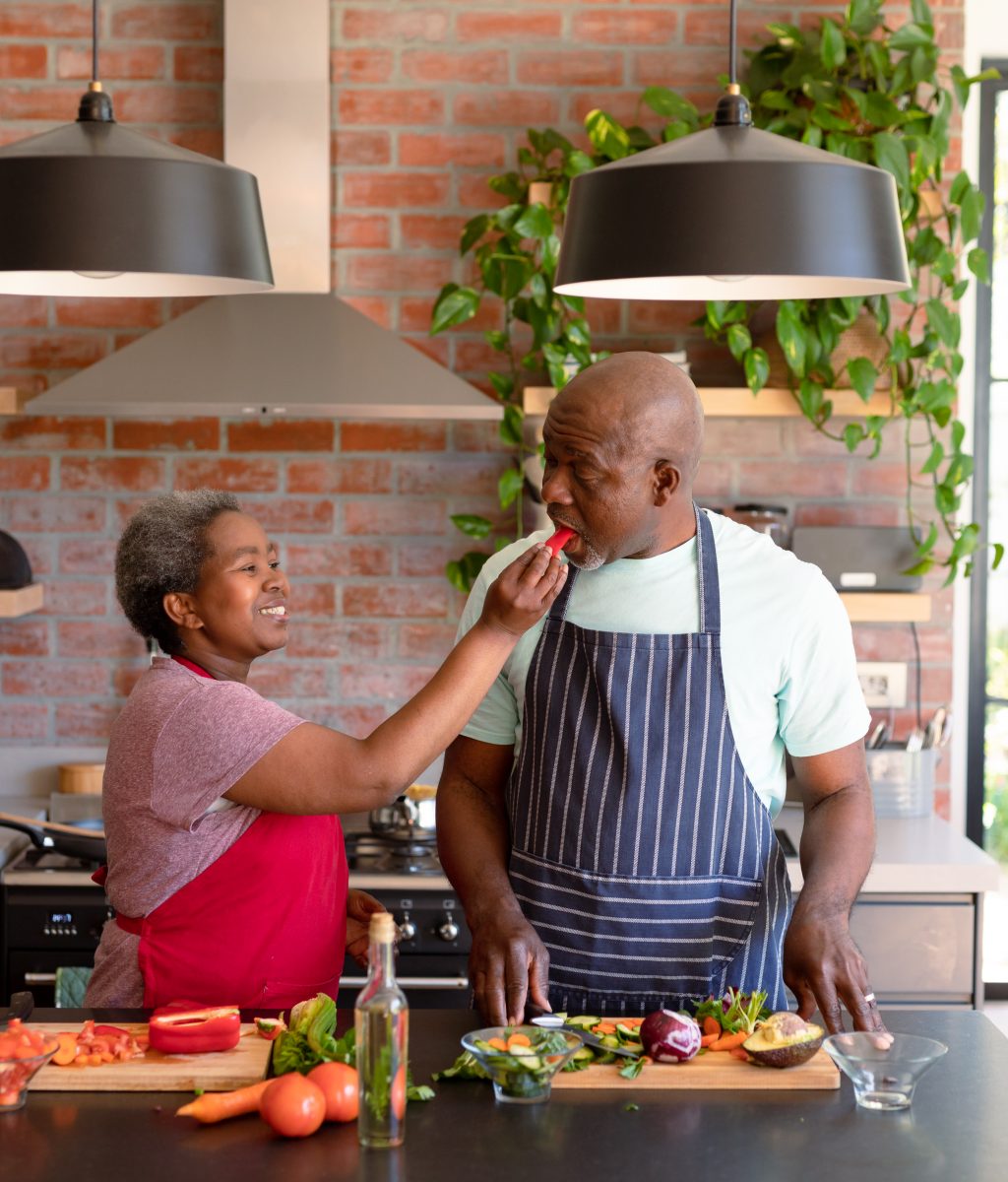 Happy african american senior couple cooking together in kitchen